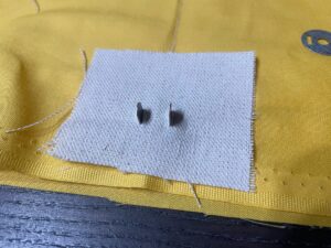 裏布とマグネットの裏打ち用布と一緒に金具を通す